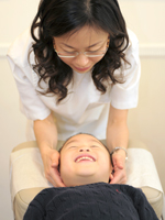Dr. Ng performs chiropractic adjustment on kids
